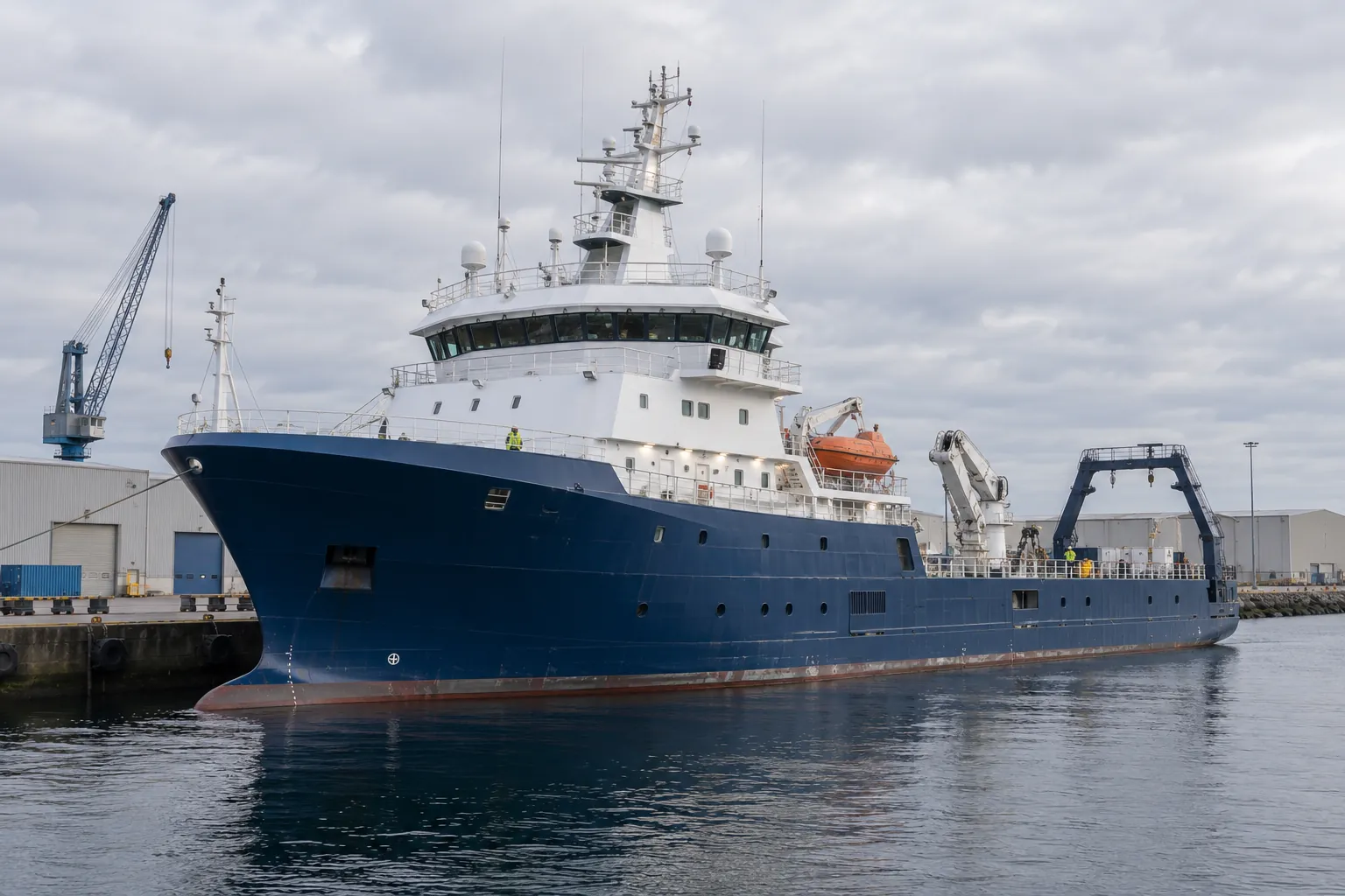 An offshore survey and research vessel moored alongside a harbour quay